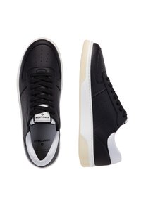 Schwarze Ledersneaker mit Perforationen, weißen Akzenten und einer strukturierten Gummisohle. Das Design umfasst einen flachen Schnürverschluss.