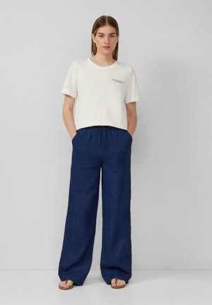 White cotton t-shirt with short sleeves and a small logo. Navy blue, wide-leg linen pants with an elastic waistband and side pockets.