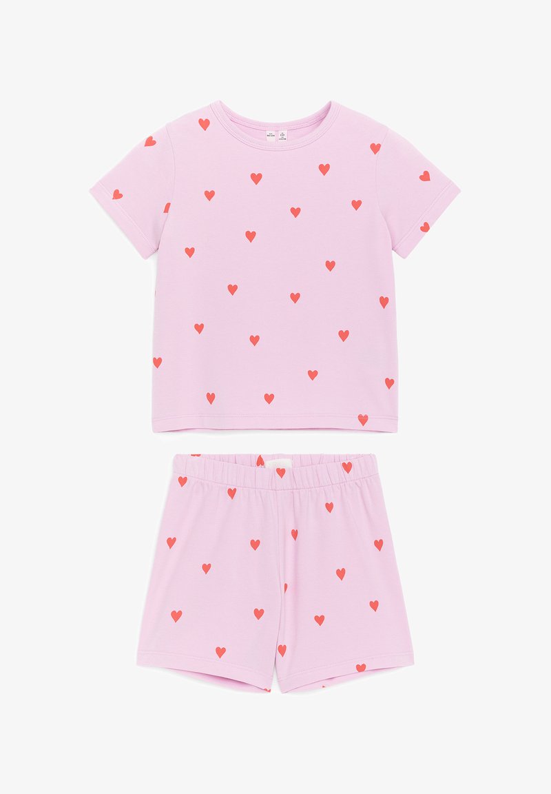 Ensemble haut à manches courtes et short rose avec motifs de cœurs rouges, avec un col rond et une taille élastique au short.