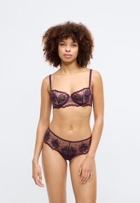 Lace lingerie set in deep purple and sheer fabric, featuring floral embroidery, adjustable straps, and scalloped edging on the bra and panties.