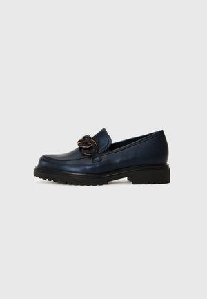 Mocassin en cuir marine à bout rond, avec un détail de chaîne décoratif et une semelle en caoutchouc noir dotée de rainures de traction. Texture lisse et design élégant.