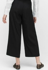 Zwarte wijde broek van lichtgewicht stof, met een platte tailleband en een enkel-lang silhouet. Gemaakt in combinatie met patroonflats.