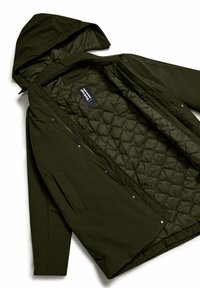 Olijfgroene geïsoleerde jas met capuchon, met een gewatteerde binnenvoering, ritssluiting en zijzakken. Soepele stoftextuur.