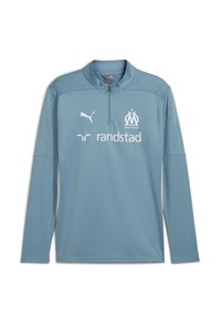 Maglietta sportiva manica lunga blu chiaro con colletto a mezza zip, dotata di spalle testurizzate e loghi bianchi di Puma e Randstad.