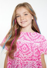 Rožinė, raštuota suknelė su balta nėrinių apdaila, turinti tain- daža dizainą. Ilgi plaukai su rožinėmis ir mėlynomis akcentų kasomis. Šypsena.