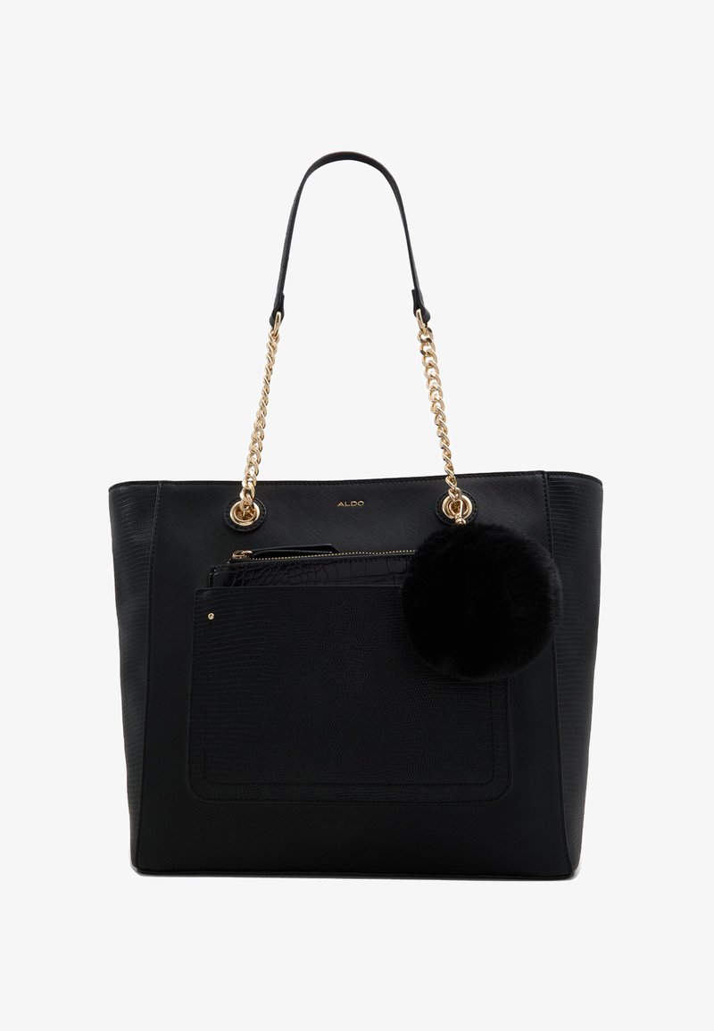 Sac fourre-tout noir texturé avec des anses en chaîne dorée, poche avant, pochette zippée à l'intérieur, et un pompon en fourrure noire rond suspendu sur le côté.