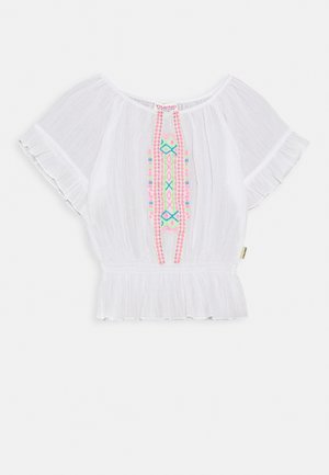 Top blanco de manga corta con un dobladillo rizado y bordado colorido que presenta patrones geométricos en rosa, azul y verde en el centro.