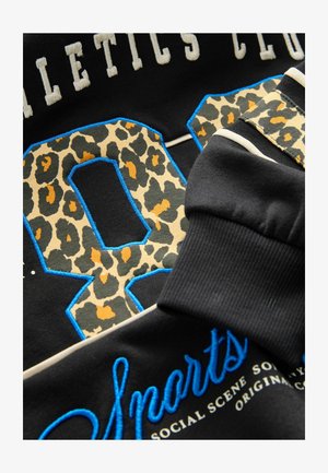 Czarny sweatshirt z przesadnie dużą leopardzową cyfrą "88" z niebieskim haftowanym obramowaniem. Napis "Athletics Club" i "Sports" w białym i niebieskim kolorze.