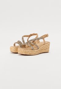 Sandali con zeppa dotati di suola in juta intrecciata naturale, cinturini nudi e dettagli metallici. Presentano una cinturina alla caviglia regolabile e design con punta aperta.