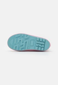 Light pink sneaker with a textured blue rubber sole, featuring a patterned tread for grip and a smooth upper edge.