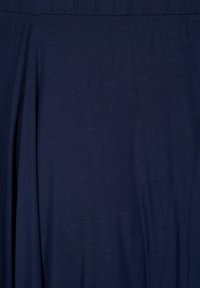 Tissu bleu marine avec une texture lisse, présentant des drapés subtils et une taille élastique. Simple, couleur unie sans motifs ni ornements.
