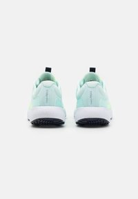 Les baskets Nike React présentent un upper vert menthe clair, une semelle blanche et une languette de talon noire, avec une finition texturée et des coutures renforcées.