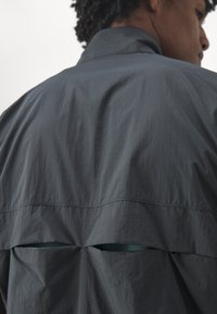 New Balance ATHLETICS REFLECTIVE PACKABLE JACKET - Veste de running - blacktop