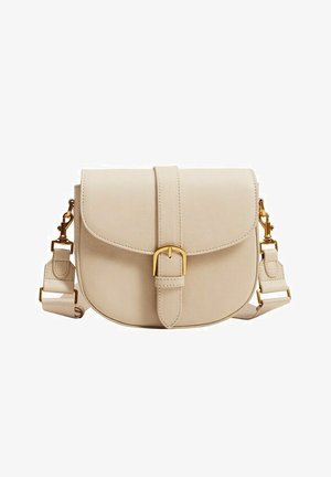 Beige leren crossbodytas met afgeronde klep, gouden gespdetail en verstelbare schouderriem met gouden sloten op een witte achtergrond.