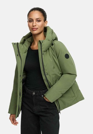 Groene pufferjack met een grote capuchon, ritssluiting, drukknopen en een ronde logo-patch op de linker mouw. Draagt over een zwarte top.