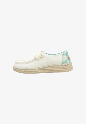Mocassin blanc décontracté avec semelle beige tressée, couture turquoise, lacet noué et accent floral turquoise au talon.