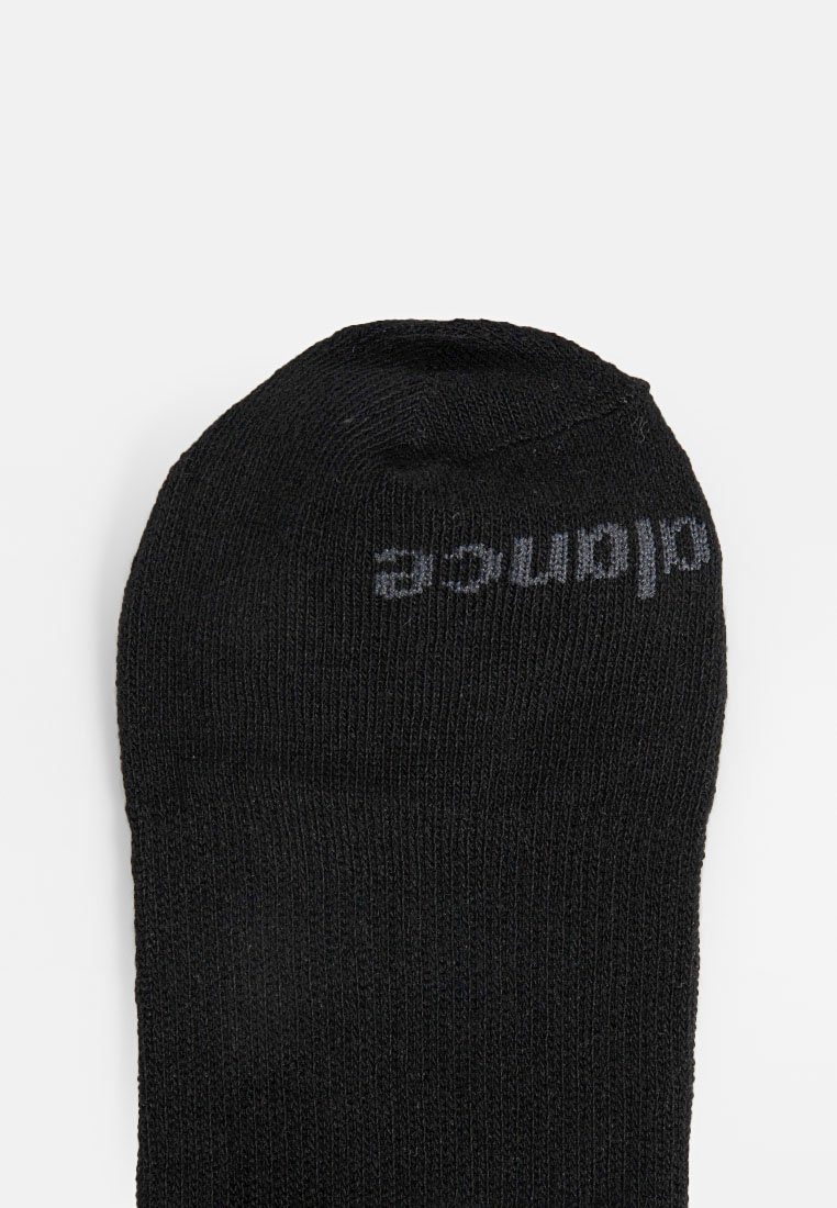 Chaussette noire avec une texture côtelée, dotée d'un orteil arrondi. Le nom de la marque est imprimé en gris sur le dessus. Design compact pour le confort.