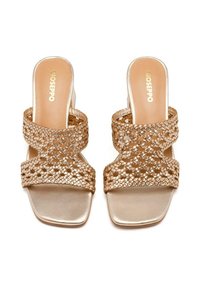 Sandales en or avec des brides tressées et un bout carré. Semelle intérieure lisse en métal et petit talon. Design minimaliste, adapté à un usage décontracté.