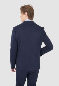 Blazer blu navy con un design strutturato, caratterizzato da una singola apertura sul retro, tessuto liscio e polsini con bottone.