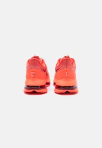 Κόκκινα αθλητικά παπούτσια με αναπνεύσιμο επάνω μέρος από δίχτυ, μαλακό κολάρο και μαύρη μαξιλαρωμένη σόλα. Διαθέτουν ομαλό, υφασματοποιημένο σχέδιο για άνεση.