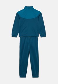 Fato de treino de duas peças em verde escuro, com uma jaqueta de gola alta, mangas raglan e punhos elásticos, acompanhada por calças a condizer.