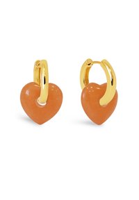 Orecchini a cerchio dorati con ciondoli a forma di cuore in pietra arancione, caratterizzati da una finitura lucida e una texture morbida.