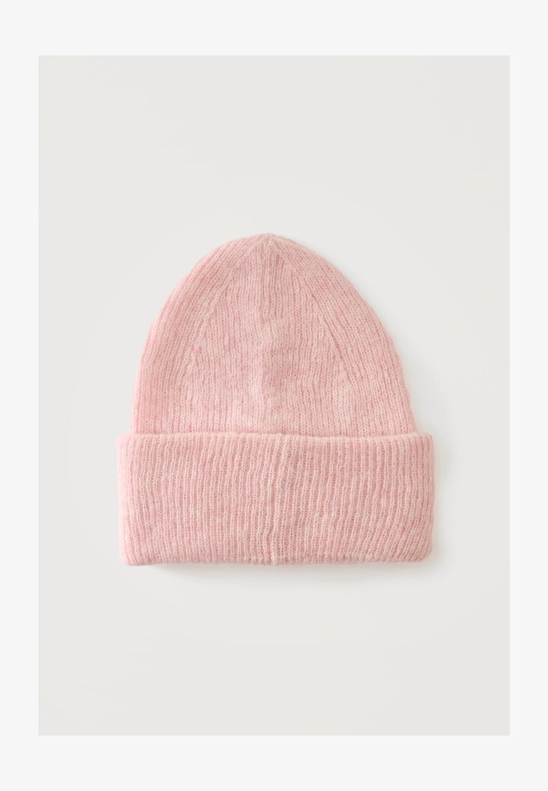 Bonnet en laine tricotée rose douce avec revers, présenté à plat sur un fond gris clair.