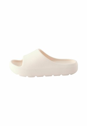 Sandale blanche à enfiler avec une surface texturée, ouverte à l'avant et avec un semelle arrondie. Elle présente un matériau doux et flexible ainsi qu'une semelle légère et profilée.