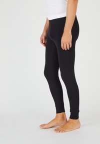 Leggings de algodón negro de corte ajustado, con una textura suave y puños de canalé en los tobillos. Diseñados para la comodidad y la movilidad.