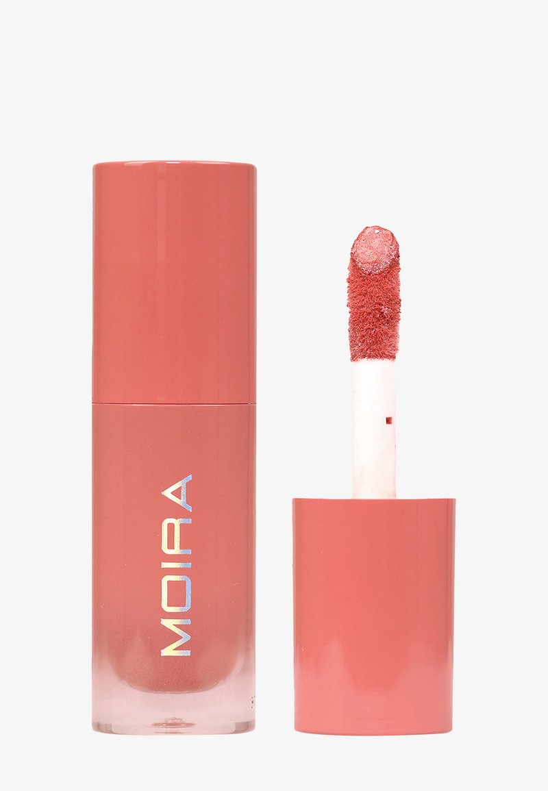 Rouge à lèvres liquide mat corail avec applicateur, nom de la marque MOIRA sur le contenant, sur un fond blanc uni.