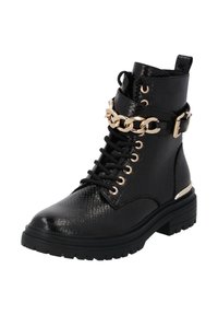 Botines negros de cuero texturizado, con un acento de cadena dorada alrededor del tobillo, parte delantera con cordones y suela de goma gruesa.