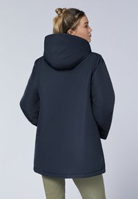 Marineblauer Parka mit Kapuze, gepolstertem Design und geradem Schnitt. Verfügt über eine glatte Textur und minimalistische Nähdetails auf der Rückseite.