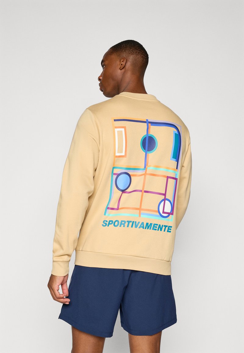 Beige sweatshirt med fargerik grafisk design på baksiden, med abstrakte former og teksten "SPORTIVAMENTE" i blått. Myk tekstur.