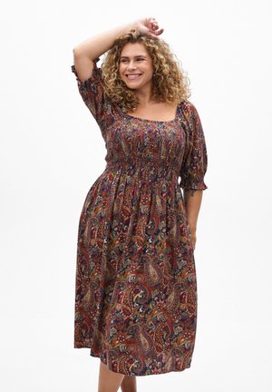 Florales Paisley-Kleid mit quadratischem Ausschnitt, kurzen Puffärmeln und rüschierter Brustpartie. Reichhaltige Farben wie Rot, Marineblau und Gold. Fließender Stoff.