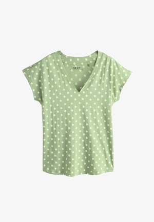 Lysegrøn kortærmet skjorte med hvide prikker og V-udskæring, lagt fladt på en hvid baggrund.