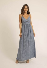 Robe maxi en tissu bleu avec un petit motif floral blanc, dotée d'un décolleté croisé, de bretelles spaghetti et d'une jupe fluide.