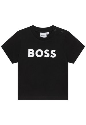 Camiseta negra de manga corta para niños pequeños con texto blanco "BOSS" en el frente y dos botones de presión en el hombro izquierdo.