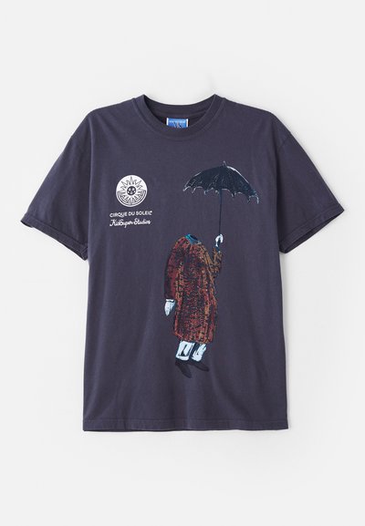 Navy cotton t-shirt featuring a headless figure in a brown coat with blue pants and black shoes, holding a black umbrella. Cirque du Soleil logo displayed.