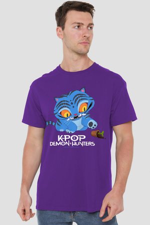 Mann trägt lila T-Shirt mit einem Cartoon-Blauen Tiger und einem kleinen umgestürzten Blumentopf, Text "KPOP DEMON HUNTERS" unter der Grafik.
