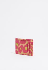 Roze kaarthouder met een luipaardprint ontwerp in geel en groen, gemaakt van gestructureerd leer met meerdere kaartsleuven aan de voorkant.