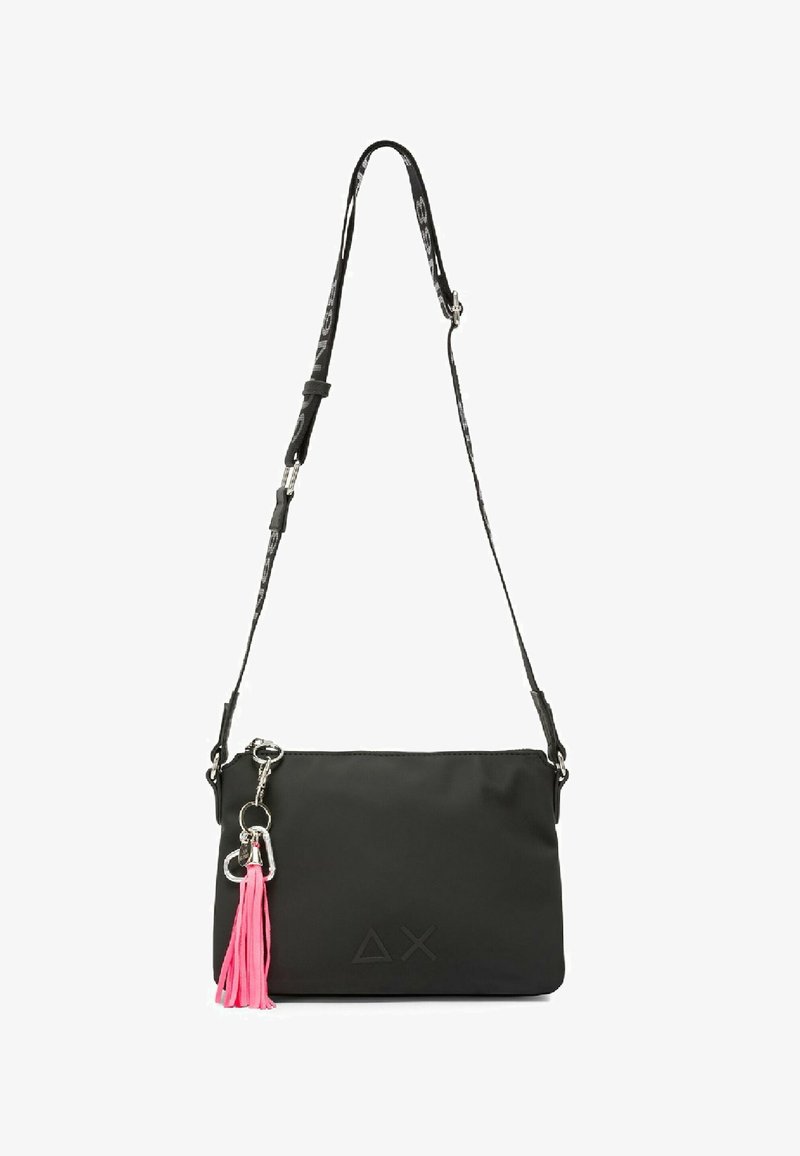 Borsa a tracolla rettangolare nera con tracolla regolabile, portachiavi argentato e accessorio a nappina rosa brillante su sfondo bianco.
