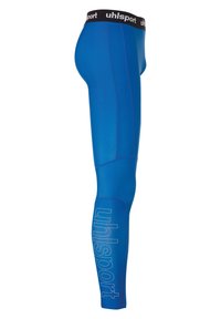 Blauwe sportlegging met een gladde, rekbare stof. Kenmerkt zich door een zwarte tailleband en een witte 'uhlsport' logo dat op het linkerbeen is gedrukt.