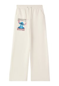 Kremowe szerokie spodnie dresowe z elastycznym pasem i sznurkiem w talii, z grafiką Stitcha obok napisu "SPORTY STITCH."