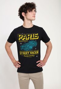 Černé tričko s grafikou modrého auta a žlutým textem "PARIS STREET RACER CHAMPIONSHIP" na pozadí s mřížkovým vzorem.