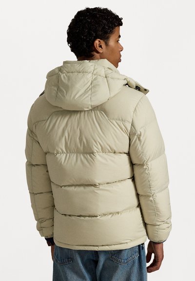 Puffer jacket in light beige with a hood, quilted design, and visible stitching. Features a two-way zipper and adjustable drawstrings.