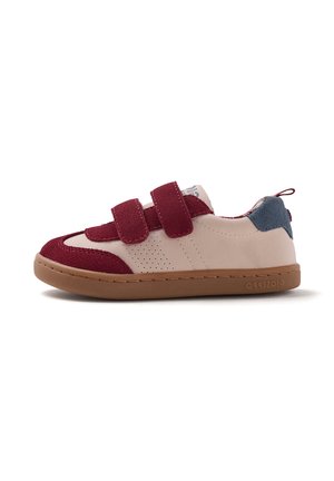 Zapatilla baja para niños con piel beige, tiras y detalles en ante burdeos, suela marrón y parche de ante azul en el talón.