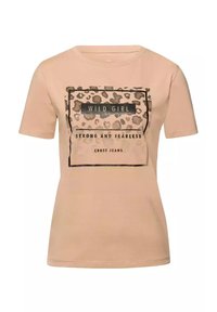 Jasno beżowa koszulka wykonana z bawełny, z grafiką w ramach w leopardzi wzór oraz napisem "WILD GIRL STRONG AND FEARLESS" w kolorze czarnym.