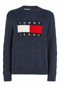 Mörkblå kabelstickad tröja med rund halsringning, med en rektangulär logotyp i röd, vit och mörkblå, samt ribbade ärmslut och nederkant.