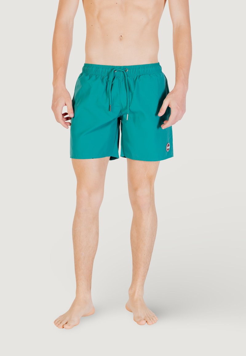 Costumi da bagno turchesi realizzati in tessuto leggero, con cintura elastica e stringa di regolazione, e tasche laterali.