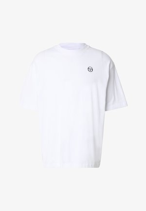 T-shirt bianca oversize a manica corta con piccolo logo circolare nero sul petto in alto a sinistra, design semplice, scollo rotondo.